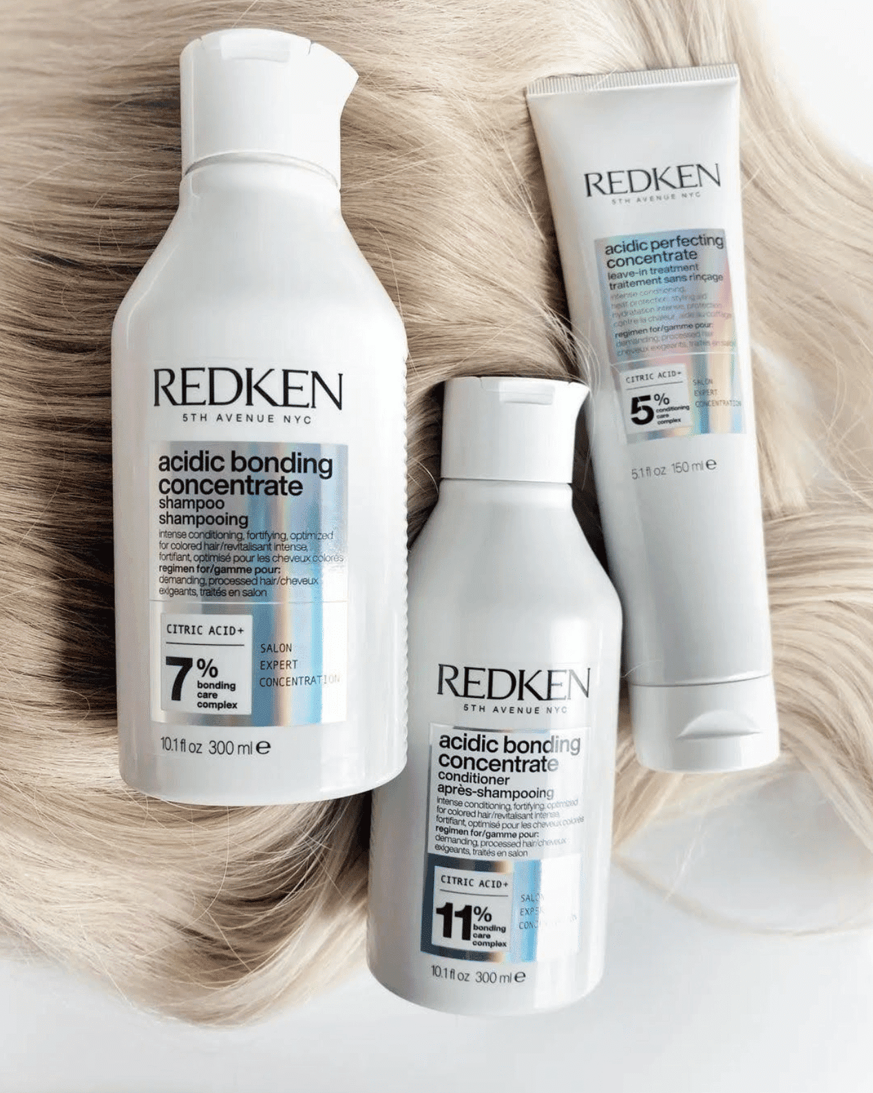 Redken acidic bonding concentrate hair care products on a light background with hair strands.